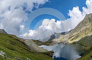 Balea lake and Balea Hotel in spring time with clouds